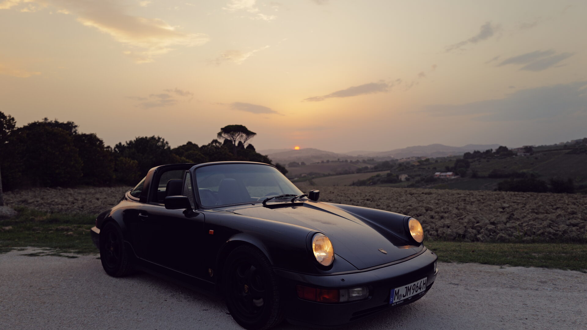 Air-cooled Porsche at dusk on a European road